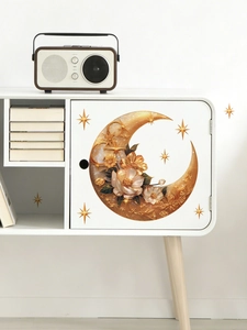 Détail d'autocollant lune et étoiles dorées avec motifs floraux sur une armoire blanche