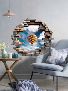 Détail d'un sticker mural 3D avec montgolfière volant à travers une brèche dans le mur