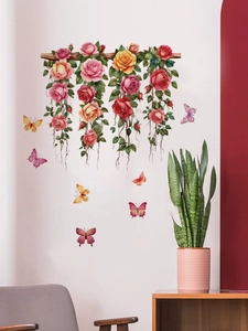 Détail de roses suspendues colorées et de papillons sur un mur blanc impeccable