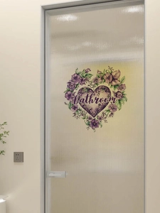 Detail of purple floral heart sticker with 'bathroom' text on frosted glass door