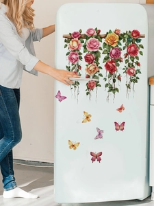 Gros plan d'autocollants muraux roses et papillons appliqués sur un réfrigérateur blanc