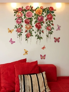 Détail de stickers muraux floraux avec roses et papillons au-dessus d'un canapé rouge