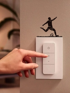 Detail view of black PVC football player silhouette sticker around a wall light switch