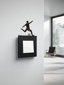 Detail of soccer player silhouette wall sticker applied on a black light switch frame