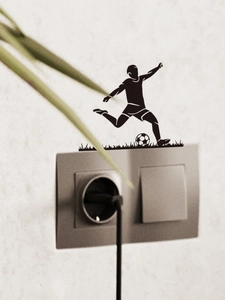 Detail of soccer player silhouette wall sticker applied around a home light switch