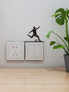 Detail of soccer player silhouette decal applied above a light switch on a white wall