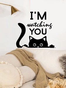 Détail d'un sticker chat noir avec texte I'M watching YOU sur un mur blanc épuré