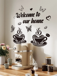 Détail du sticker Welcome to our home avec tasses de café et papillons sur un mur blanc