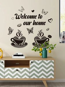Détail du sticker mural café Welcome to our Home avec papillons et cœurs sur le mur