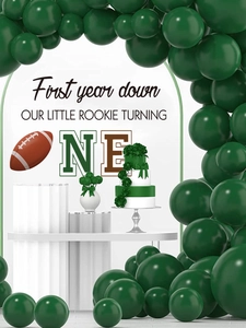 Détail de fête d'anniversaire football avec arche de ballons vert foncé et décor