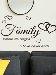Detail of black vinyl wall sticker with family quote and hearts on white living room wall