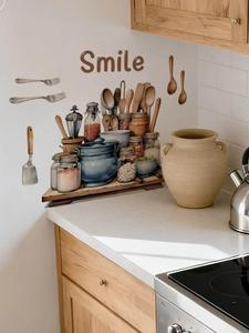 Detail of kitchen wall decal featuring blue pot and spice jars on white tile background