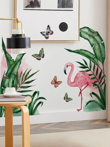 Close-up of tropical watercolor flamingo and green leaf wall stickers on a white wall