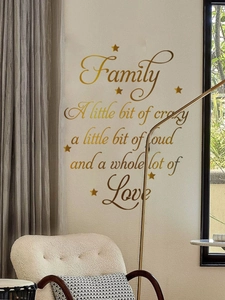 Détail d'un sticker mural doré avec citations familiales et étoiles dans un salon