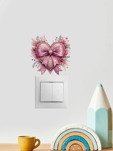 Detail of pink heart-shaped wall sticker with bow and floral patterns over light switch