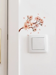 Detail of pink cherry blossom wall stickers with petals above a white light switch