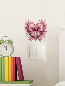 Pink heart and bow decorative wall sticker applied above a white light switch