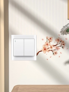 Close-up of white double light switch with indicator light and floral wall stickers