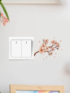 Detail showing pink floral branch PVC wall stickers applied around a light switch