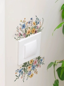 Detail view of watercolor wildflower wall stickers applied on a white light switch panel
