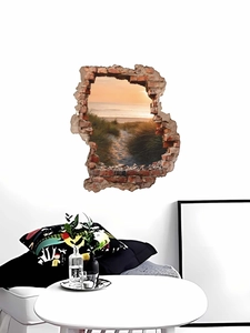 Detail view of 3D cracked wall decal featuring a scenic beach sunset on white interior wall