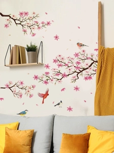 Detail of pink cherry blossom branches and colorful birds wall decals in a cozy room