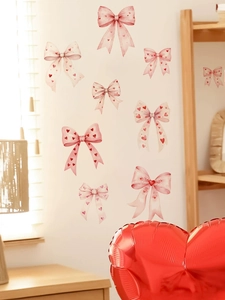 Dettaglio di adesivi murali fiocco rosa con motivi a cuore in un ambiente accogliente