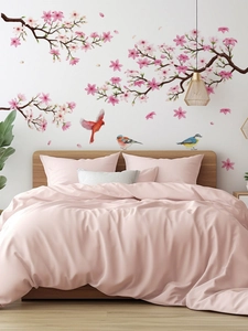 Detail of cherry blossom wall stickers with birds in a cozy bedroom setting