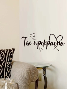 Détail d'un sticker mural en russe 'Ты прекрасна' de style manuscrit pour le salon