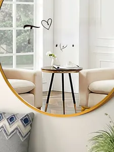 Détail d'un miroir mural avec cadre en métal doré reflétant un décor intérieur moderne