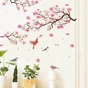 Cherry blossom branch and bird wall decals in watercolor style on a white bedroom wall