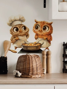 Detail of cute owl chef stickers on a kitchen wall featuring cooking pans and wooden spoons