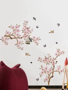 Detail view of pink peach blossom wall decals with birds and butterflies on white wall