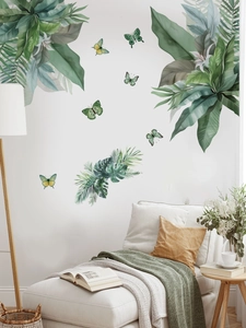 Detail of tropical palm leaves and butterfly wall stickers in a cozy bedroom setting
