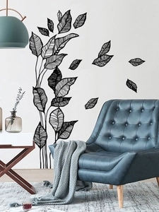 Detailed view of minimalist black leaf wall decals in a modern living room setting