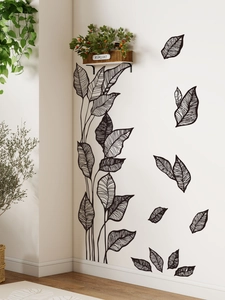 Detailed close-up of black leaf wall stickers with fine vein patterns on a neutral wall