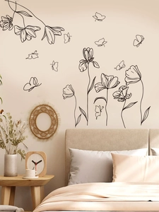 Detailed macro of black minimalist floral and butterfly wall stickers in a cozy bedroom