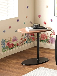 Detail view of walnut top oval side table with black metal stand in cozy living room setting