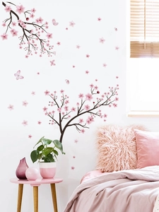 Detailed view of pink cherry blossom wall stickers with butterflies on a white bedroom wall