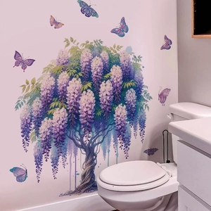 Adesivi murali con glicine viola e farfalle applicati su una parete bianca del bagno