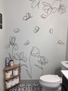 Minimalist black floral line art wall stickers with butterflies in a bathroom setting