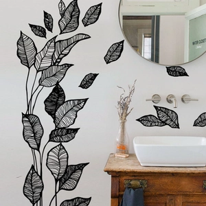 Minimalist black leaf wall decals in a modern bathroom setting over a wooden vanity