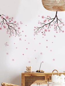 Detail of pink cherry blossom wall decals with flying butterflies in a cozy room setting