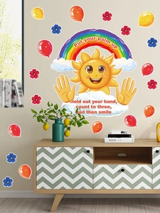 Detail of colorful sun and rainbow wall stickers with motivational text on nursery wall