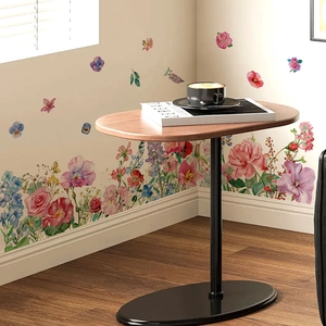 Modern oval walnut wood side table with black metal base and floral wall stickers