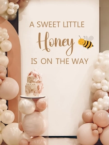Detail view of Sweet Little Honey Baby Shower backdrop with gold lettering and balloon arch