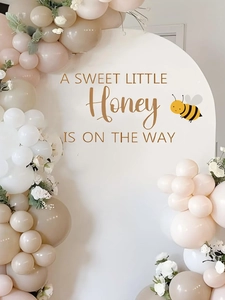 Detail of bee themed baby shower backdrop with text A Sweet Little Honey Is On The Way