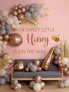 Detail of honey bee theme balloon arch set with sweet little honey backdrop for baby shower