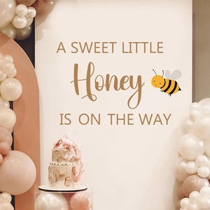 Bee themed baby shower party backdrop with sweet honey text and balloon arch decor