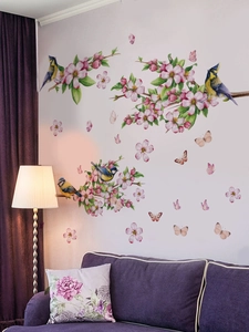 Detail view of peach blossom wall decals with realistic birds and butterflies on a white wall